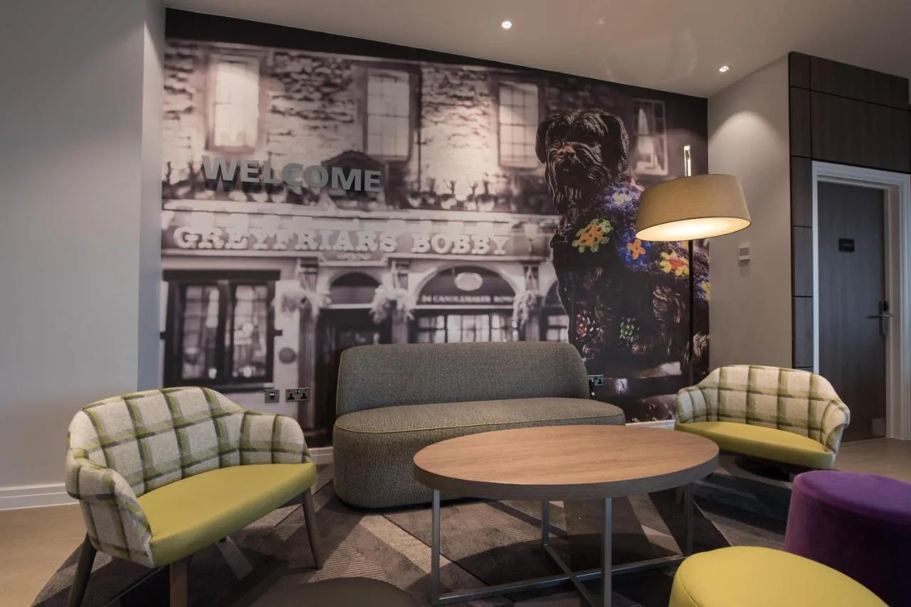 A living room with chairs and a mural at Hampton by Hilton Edinburgh West End