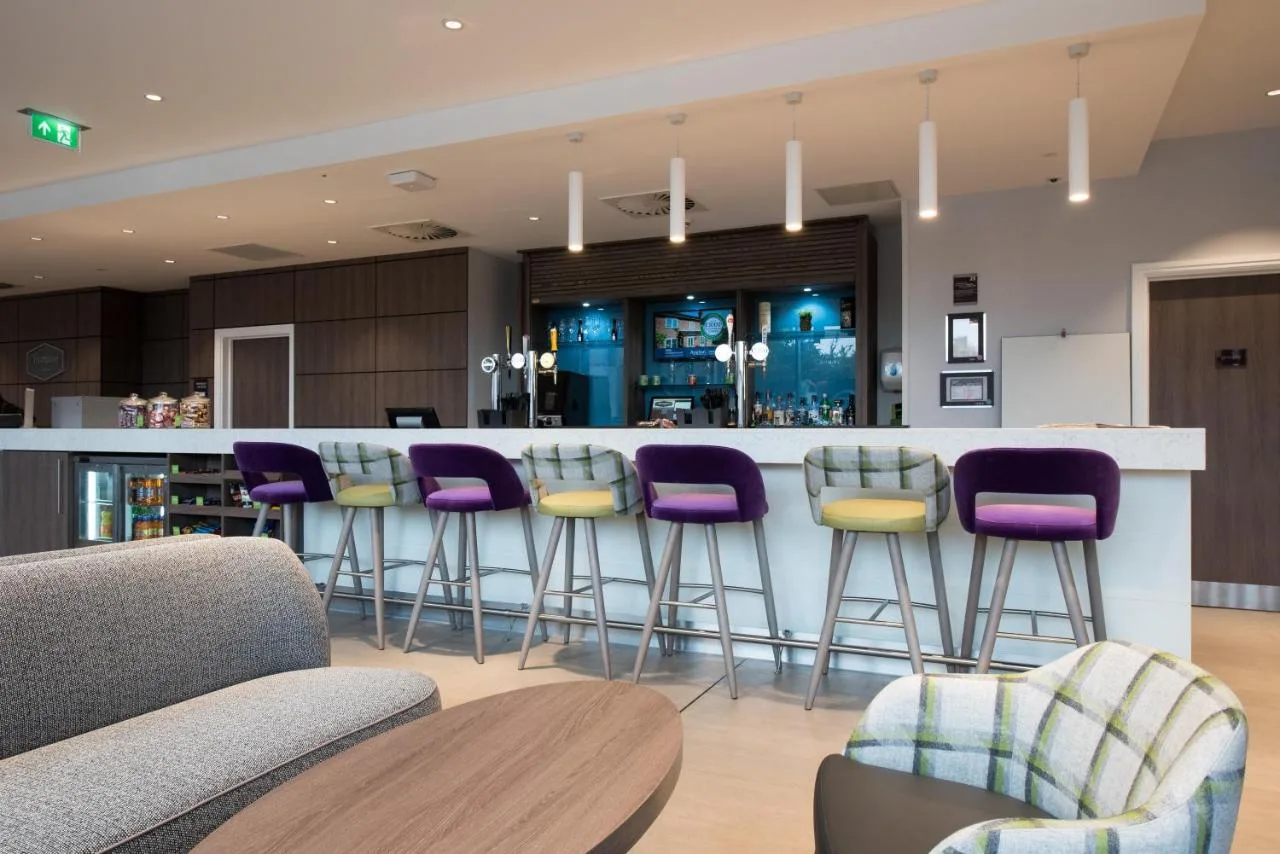 A bar with purple stools at Hampton by Hilton Edinburgh West End