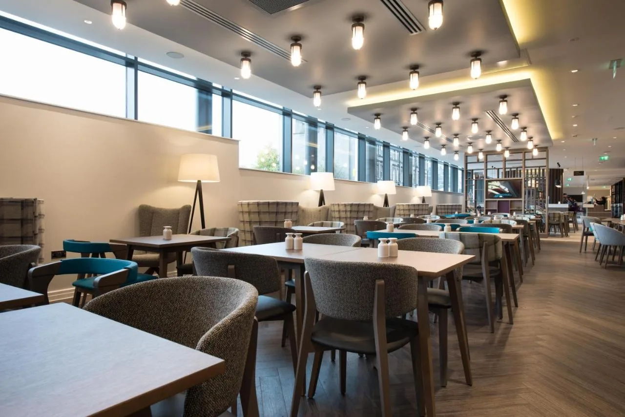 A restaurant with tables and windows at Hampton by Hilton Edinburgh West End