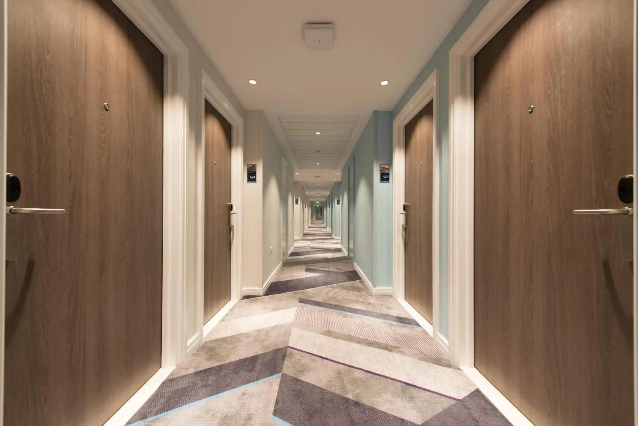 A hallway with wooden doors and tiled floors at Hampton by Hilton Edinburgh West End